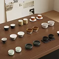 Various Colored Cups And Bowls In Different Shapes Arranged On Wooden Table With Posters