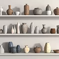 Various Ceramic Vessels in Different Colors and Shapes on White Shelves