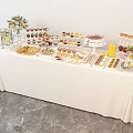 Elegant Dessert Table With White Tablecloth Decorative Flowers And Assorted Sweet Treats