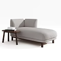 Light Gray Chaise Lounge With Wooden Side Table And Stack Of Books