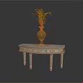 Light Colored Wooden Table With Drawers And Decorative Green Vase Holding Fern Plant