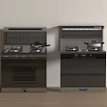 Two Black Integrated Stoves Placed Side By Side On Light Colored Floor Against White Wall