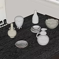 White Textured Ceramic Vessels Including Bowls Plates and Vases Arranged on Dark Wooden Table