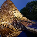 Modern Wooden Curved Pergola With Water Reflection Green Trees And Blue Sky