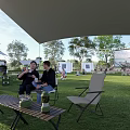 Scenic Campsite With Green Grass Canopy Chairs Tables People Relaxing And Children Playing