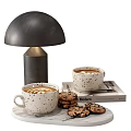 Speckled Coffee Mugs With Cookies On Table Alongside Modern Lamp And Book