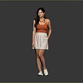 Woman in Orange Tank Top White Skirt and White Shoes Standing Against Gray Background