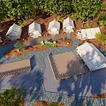 Campsite with Tents Wooden Fence and Tables in Natural Setting Under Red Sunset Sky