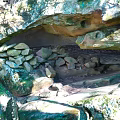 Natural Rock Cave Formation With Stacked Stones And Lush Green Vegetation