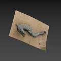 Realistic Crocodile Sculpture Lying On Sandy Surface With Detailed Textured Skin