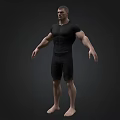 Muscular Man In Black Tight Shirt And Shorts Standing Barefoot On Dark Background