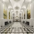 Elegant Classical Hotel Lobby With Grand Chandelier Murals Arched Doorways And Checkered Floor
