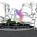 Colorful Feather Shaped Sculpture as Centerpiece in Circular Fountain with Trees and Flowers