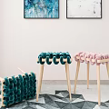 Green and Pink Woven Stools with Light Wooden Legs in Indoor Geometric Rug Setting