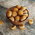 Freshly Baked Small Round Rolls In Wicker Basket On Wooden Tabletop And Scattered Around