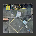 Different Colored Trash Bins And Wall Mounted Fans Near Brick Wall On Ground With Rubbish
