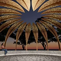 Pergola Featuring Golden Leaf Shaped Structure Illuminated Under Evening Sky With Trees And Circular Platform