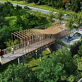 Elevated Wooden Observation Deck With Lush Trees Green Grass Scenic Walkway And Natural Surroundings