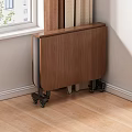 Foldable Wooden Dining Table With Wheels Against Wall On Wooden Floor