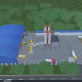 Industrial Factory Building With Blue Roof Red Storage Silos Surrounded By Green Trees And Trucks