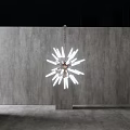 Modern Starburst Chandelier with White Light Fixtures in Minimalist Interior with Concrete Wall
