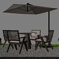 Outdoor Table With Chairs and Umbrella in Gravel Area Decorated With Green Plants