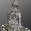 Stone Carved Buddha Sculpture In Sitting Posture With Moss And Fallen Leaves