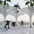 Modern Garden Landscape with White Tree like Lattice Structures Palm Trees and People Activities