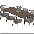 Wooden Dining Table Set With Eight Gray Cushioned Rattan Chairs And Decorative Vase On Tabletop