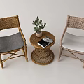 Cozy Rattan Table And Chair Set With Gray White Cushions Potted Plant And Book