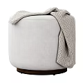 Light Gray Upholstered Round Ottoman With Knitted Plaid Blanket And Dark Wooden Base