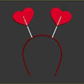 Red Decorative Headband With Two Sparkly Heart Shaped Ornaments on Gray Background