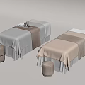 Elegant massage beds with cream and white linens and matching stools.