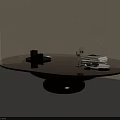 Modern Round Glass Top Coffee Table With Black Base And Decorative Books And Glasses
