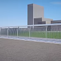 Modern Metal Railings Along Urban Road With Green Grass And Buildings