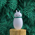 White Rabbit Shaped Daily Electrical Appliance Placed On Wooden Stump With Green Fern Plants