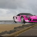Pink Sports Car Parked By Seaside With Ocean View And Cloudy Sky