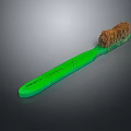 Close Up View Of Green Handle Toothbrush With Brown Bristles On Dark Background