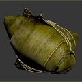 Traditional Chinese Zongzi Wrapped in Green Bamboo Leaves and Tied with String on Dark Glossy Surface