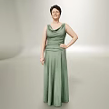 Elegant Woman in Green Long Dress Posing with Hand on Hip Against Neutral Gray Backdrop