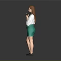 Red Haired Woman In White T-Shirt With Colorful Graphic Green Skirt And Black Shoes Holding Smartphone