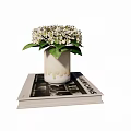 White Hydrangea Flowers In Ceramic Vase With Drip Design On Stacked Books
