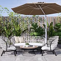 White Wicker Outdoor Sofa with Umbrella Chairs and Coffee Table in Lush Patio Garden