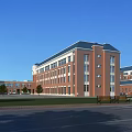 Red Brick Multi Story School Building With Green Lawn Trees And Open Plaza
