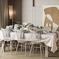 Elegant Dining Table Set With White Tablecloth Floral Centerpiece Tableware Chairs And Abstract Wall Art