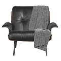 Modern Black Leather Armchair with Wooden Frame and Gray Knit Blanket on Metal Legs