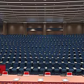 Large Conference Hall Interior With Stage Large Screen Party Emblem Red Background And Arranged Seats