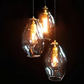 Three Glass Pendant Lights Hanging With Lit Warm Glow In Dark Background