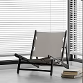 Modern Leisure Chair With Black Frame Light Colored Seat And White Blinds Near Books