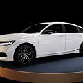 Modern White Sedan Car Featuring Sleek Exterior And Alloy Wheels On Display Stand